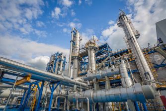 Chemical plant facility with industrial structures and pipes.