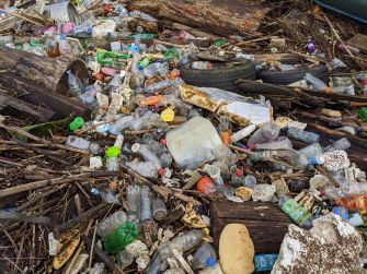 A large collection of trash, including plastic bottles and debris, littering a waterway.
