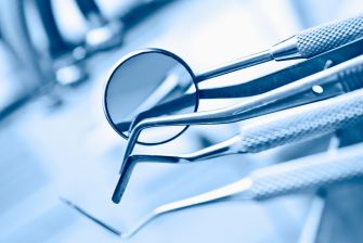 Dental tools and instruments arranged on a surface with a focus on a dental mirror.