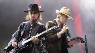 Members of Jane's Addiction performing on stage during a live concert.