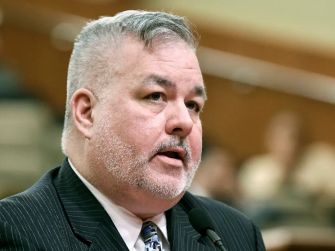 A man speaking at a legislative session regarding the Gender Recognition Act in New York.