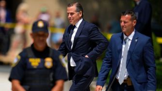 Hunter Biden walking with security personnel amidst ongoing legal issues.