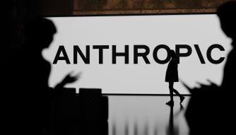 Silhouetted people in front of a large sign reading ANTHROPIC.