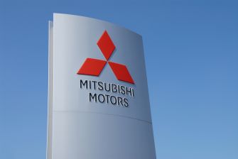 Mitsubishi Motors company sign against a clear blue sky.