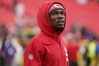Kansas City Chiefs wide receiver Rashee Rice in a red hoodie during warm-ups at a stadium.