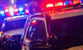 Police vehicles with flashing lights at a nighttime scene.