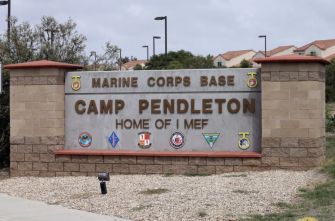 Entrance sign for Marine Corps Base Camp Pendleton with base name and unit insignia.