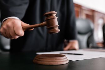 A judge's gavel being brought down in a courtroom setting.