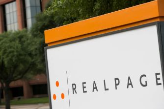 Signage for RealPage, a Texas-based property management software company, with a modern office building in the background.