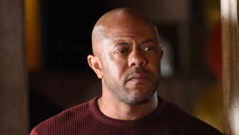 A man with a serious expression appearing in a scene from a dramatic television series.