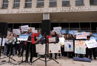 A crowd of protesters outside the U.S. Department of Education, holding signs advocating for education funding and diversity programs.