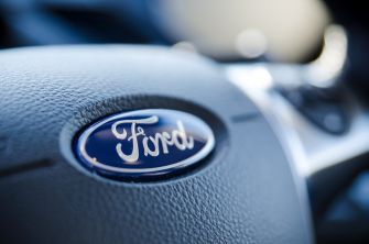 Close-up of a Ford logo on the steering wheel of a vehicle.