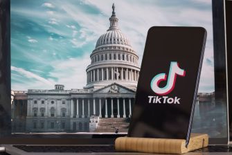Smartphone displaying TikTok logo in front of the U.S. Capitol building, symbolizing the legislative debate surrounding the app's potential ban in the United States.