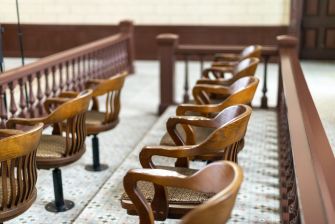 Empty jury chairs in a courtroom.