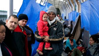 Asylum seekers wait in a shelter, demonstrating the impact of immigration policies on families and individuals seeking refuge.