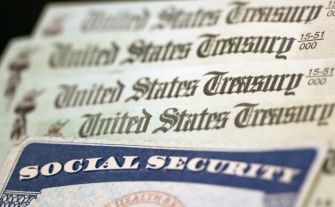 Stack of U.S. Treasury checks with a Social Security card on top.