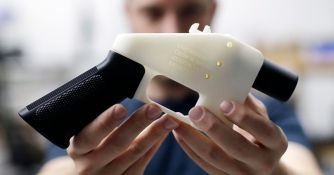 A person holding a 3D-printed gun, demonstrating the untraceable nature of these firearms.