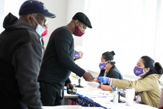 Voters being assisted at a polling station during the election process.