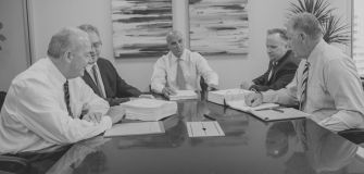 Group of attorneys discussing a class-action lawsuit related to insurance coverage for pain management devices.