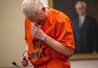 Former attorney Alex Murdaugh in an orange prison jumpsuit appears emotional during his sentencing for financial crimes.