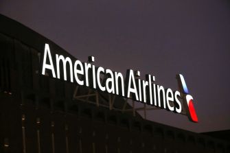 Signage for American Airlines illuminated at night.