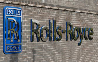 Signage of Rolls-Royce displayed on a brick wall, emphasizing the company's branding.