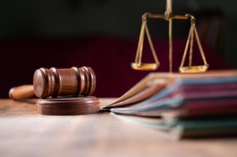 A gavel and scales of justice on a wooden desk, symbolizing legal proceedings and the balance of law.