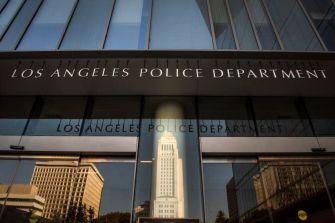 Exterior view of the Los Angeles Police Department building with reflection of the city hall.