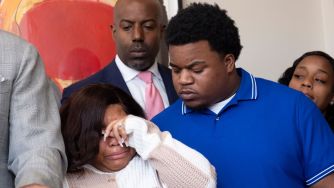 Parents grieving at a press conference following the death of their newborn during delivery.