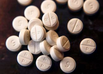 Prescription opioid pills scattered on a surface.