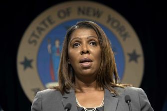 New York Attorney General Letitia James speaking at a press conference with the state seal in the background.