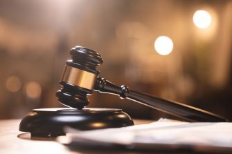 A gavel resting on a wooden base, symbolizing legal proceedings and justice.