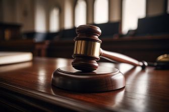 A wooden gavel resting on a judge's bench in a courtroom setting.