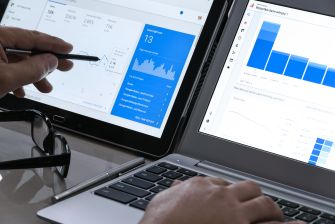 A person analyzing SEO data and website analytics on multiple screens.