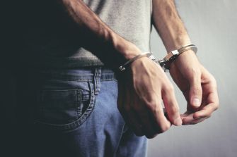 Hands in handcuffs, representing an arrest.