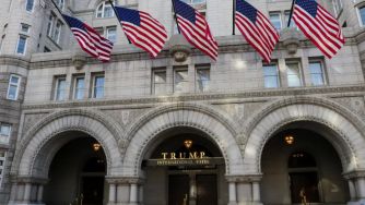 Trump International Hotel with American flags displayed prominently outside the building.