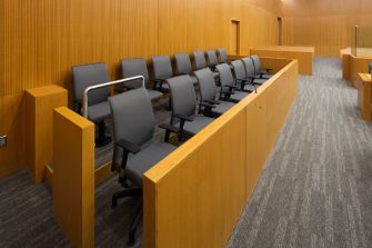 A view of empty jury seats in a courtroom setting.