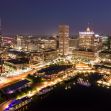 Aerial view of the Baltimore skyline at night, showcasing the city's illuminated buildings and harbor.