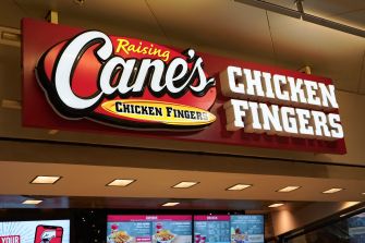 Raising Cane’s Chicken Fingers sign inside a mall restaurant.
