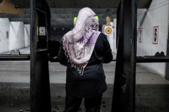 A Muslim woman wearing a hijab at a gun range.